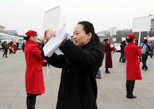邰丽华委员为身着红衣的饭店迎宾员拍照