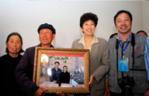 中国文联党组书记、副主席赵实和图片作者包旭东与被拍摄贫困户合影