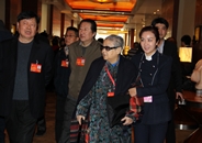 全国政协委员李世济在工作人员的搀扶下来到会场