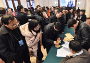 参加全国政协十二届三次会议采访报道的记者领取证件