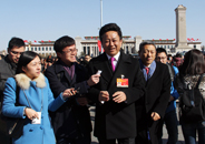 全国政协委员、中央电视台主持人朱军一边接受记者采访一边步入会场.JPG