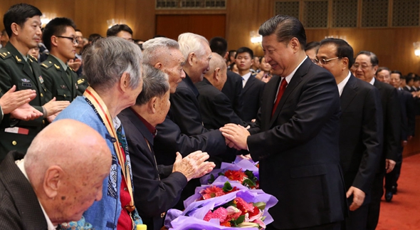 习近平与老红军代表亲切握手，向他们致以崇高敬意