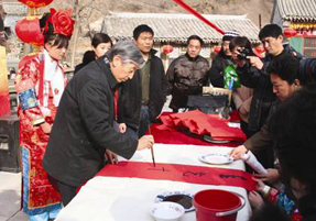 2006年1月23日,中国书法进万家行动计划在京启动。图为中国书协主席张海为农家书写春联。.jpg