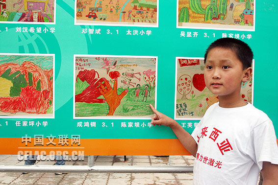 绵阳九洲体育馆,5月30日晚7点,来自北川陈家坝小学的成鸿钢(9岁,现就读九洲帐篷学校三一班)指着自己的画说:“伸出你的一双手”表示要伸出自己和其他小朋友的双手,去帮助“受灾的人”,废墟外的一只手拉着埋在废墟里的受伤的手,人与人拉着手,心与心也拉着手。中国文联网