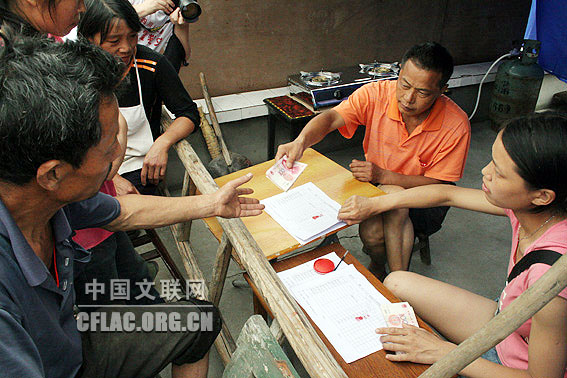 5月31日,四川绵竹“年画村”棚花村村民在领取救助金,目前每人每天10元,一次领取一个月的数额。中国文联网