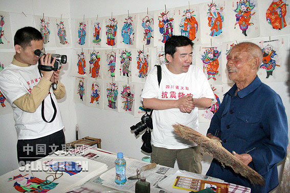 5月31日,中国艺术报(中国文联网)赴四川抗震救灾一线采访组探访绵竹射箭台村民间老艺人、年画大师陈兴才。老人今年89岁,平时坚持田间劳动,态度幽默,地震后始终保持着乐观精神。他正在向记者展示他的年画作品。中国文联网