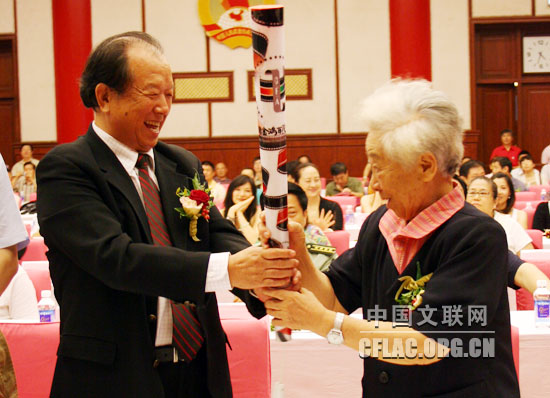 7月8日,中国电影家协会成立六十周年庆祝大会在全国政协礼堂举行。图为李前宽、于蓝传递火炬。中国文联网 吴月玲摄影报道