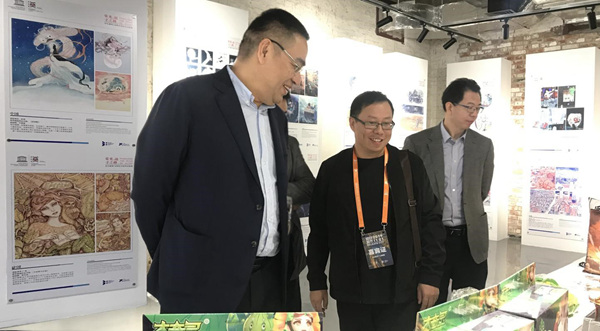 策展人叶佑天向武汉市委宣传部副部长吴天勇详细介绍动漫作品
